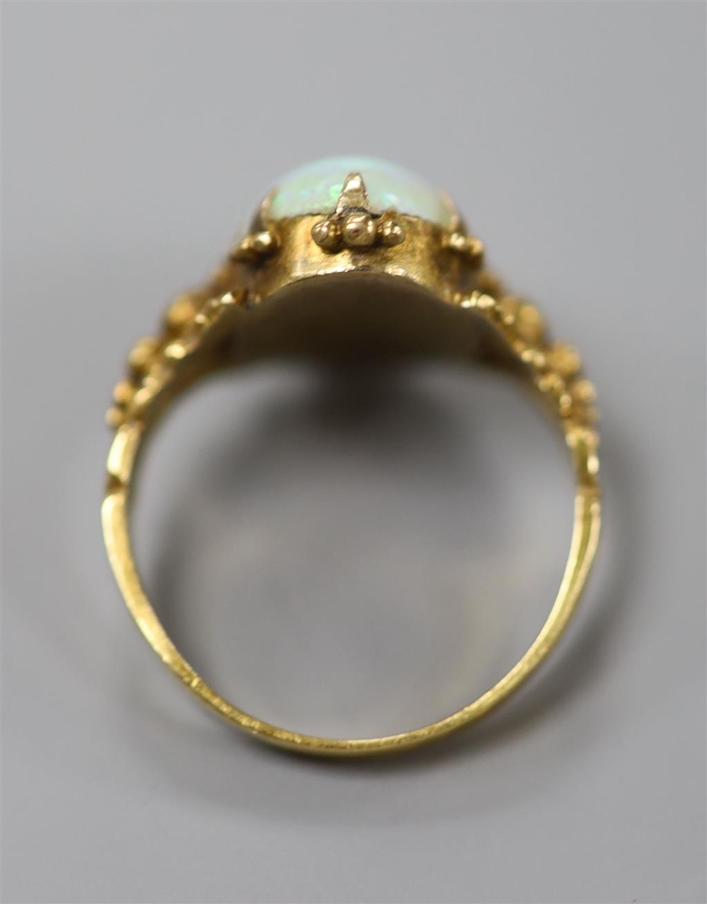 A 19th century yellow metal and oval white opal set dress ring, size M, gross 4.1 grams.